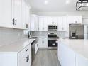 Modern kitchen with stainless steel appliances, quartz countertops, and shaker cabinets at 110 Alta Vista Way, Davenport, FL 33837