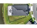 This aerial shot features the home's roof and patio with outdoor furniture surrounded by green grass at 1130 Pando Loop, Orlando, FL 32824