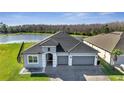 Stunning aerial view of a home near a pond with a well-maintained lawn and an oversized driveway at 1130 Pando Loop, Orlando, FL 32824