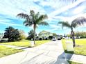 Inviting two-story home with a long driveway, lush lawn, mature palm trees, and ample parking spaces at 1201 Providence Blvd, Kissimmee, FL 34744