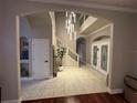 Bright foyer featuring elegant light fixture, staircase, decorative front doors, and neutral-toned tile flooring at 1201 Providence Blvd, Kissimmee, FL 34744