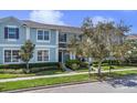 Beautiful two-story blue townhome with manicured lawn, trees, and clear sky at 1578 Softshell St, St Cloud, FL 34771