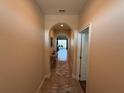 Inviting hallway with neutral paint, tile flooring, and an archway leading to the main living area at 199 Macaulays Cv, Haines City, FL 33844