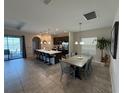 Open-concept kitchen and dining area with a large island, pendant lights, and backyard views at 199 Macaulays Cv, Haines City, FL 33844