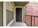 Condo front door with a brick accent wall, a window, and black railings at 2210 Yankee Pl # 334, Orlando, FL 32839