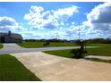 Landscaped street view in a quiet residential neighborhood with a paved driveway and sidewalks at 2235 Emperor Dr, Kissimmee, FL 34744