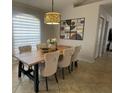 Bright dining area with a modern light fixture, stylish table and chairs, and elegant wall decor at 24 Cordona Dr, Kissimmee, FL 34758