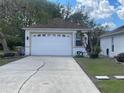 Spacious two car garage with a large driveway and mature shade trees at 24 Cordona Dr, Kissimmee, FL 34758