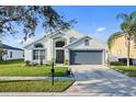 Inviting single-story home with a two-car garage, lush lawn, and decorative landscaping at 3686 Ricky Ln, St Cloud, FL 34772