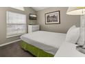 Cozy bedroom featuring a full size bed, window with blinds, and neutral decor at 4614 Falcon Ave, Kissimmee, FL 34746