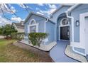 Close up of a charming blue single Gathering home with a well-manicured lawn and covered entry at 4614 Falcon Ave, Kissimmee, FL 34746