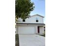 Two-story home with a two-car garage, concrete driveway, and a combination of vertical siding and shingle siding at 49 Inconnu Dr, Poinciana, FL 34759