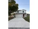 Two-story home with a two-car garage and a red front door on a spacious lot at 49 Inconnu Dr, Poinciana, FL 34759