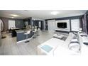 Wide-angle view of a contemporary living space, showcasing a large sofa, breakfast bar, and tiled floors at 5640 Silver Thistle Ln, St Cloud, FL 34772