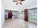 Bright, airy living room featuring tile floors, large windows, and a unique brick accent at 707 Divot Ln, Poinciana, FL 34759