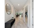 Inviting entryway featuring a large decorative mirror, decorative lighting, and tile flooring throughout the home at 7649 Wilmington Loop, Kissimmee, FL 34747