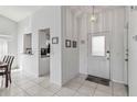Bright entryway with white tile flooring, white walls, and an open view to the kitchen at 7706 Water Oak Ct, Kissimmee, FL 34747