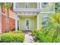 Close-up of a charming green home's entrance with landscaped garden, enhancing curb appeal at 8029 Sandy Toes Way, Kissimmee, FL 34747