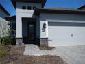 Close up on the charming single-Gathering home featuring a gray exterior with decorative front door at 1359 Greenfield Loop, Kissimmee, FL 34747