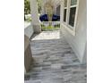 Covered front porch features stylish wood-look tile flooring and plenty of natural light at 14419 Magnolia Ridge Loop, Winter Garden, FL 34787