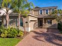 Two-story home with a brick-paved driveway, well-manicured landscaping, and a two-car garage at 15129 Driftwood Bend St, Winter Garden, FL 34787