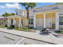 Charming townhome with bright yellow exterior, white columns, and well-maintained landscaping at 1645 Retreat Cir, Clermont, FL 34714