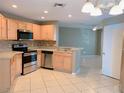 Open kitchen featuring stainless steel appliances, wood cabinetry, and breakfast bar at 181 Whisper Wood Ct, Kissimmee, FL 34743