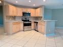 Well-lit kitchen boasting stainless steel appliances, wooden cabinets, and light countertops at 181 Whisper Wood Ct, Kissimmee, FL 34743