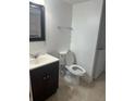 Cozy bathroom featuring a white toilet, vanity, sink, dark brown cabinets, and a mirror at 1926 Cattleya Dr, Kissimmee, FL 34741