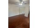 Bedroom featuring laminate wood flooring, ceiling fan, and a closet with mirrored doors at 1926 Cattleya Dr, Kissimmee, FL 34741
