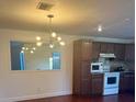 Kitchen featuring dark wood cabinets, a new white range and microwave and updated light fixture at 1926 Cattleya Dr, Kissimmee, FL 34741