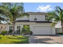 Charming two-story home with a well-manicured lawn and mature palm trees at 2129 Stillwood Way, St Cloud, FL 34771
