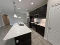 Modern kitchen featuring dark wood cabinets, a center island, and stainless steel appliances at 220 Brookes Pl, Haines City, FL 33844