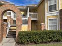 Charming yellow condo building with brick features, private balconies, and lush green landscaping at 2494 Sweetwater Club Cir # 55, Kissimmee, FL 34746