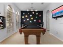 Spacious game room featuring a stylish pool table, unique wall art, and natural light at 2663 Sand Hill Point Cir, Davenport, FL 33837