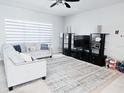 Bright living room with contemporary furnishings, neutral tones, and large window for natural light at 2663 Sand Hill Point Cir, Davenport, FL 33837