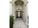Inviting front entryway featuring decorative columns and a charming, secure front door at 311 N Hampton Dr, Davenport, FL 33897
