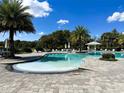 Resort-style community pool featuring ample seating and a shaded gazebo on a sunny day at 3240 Songbird Cir, Harmony, FL 34773