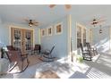 Relaxing covered front porch featuring rocking chairs, ceiling fans, and a welcoming atmosphere at 3308 Cat Brier Trl, Harmony, FL 34773