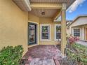 Covered entrance with brick pavers, decorative plants, and a well-lit doorway providing a welcoming first impression at 412 Grand Canal Dr, Kissimmee, FL 34759