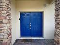 Close-up of double blue front doors framed by stone columns and a 'Welcome Home' mat at 4602 Cumbrian Lakes Dr, Kissimmee, FL 34746