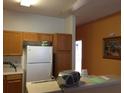 Functional kitchen with white appliances, wood cabinets, and breakfast bar at 516 Brentford Ct, Kissimmee, FL 34758