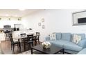 Open-concept living room with modern finishes, dining area, and a comfortable blue sofa at 5364 Diplomat Ct # 106, Kissimmee, FL 34746