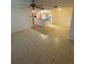 Expansive living area featuring durable tile flooring, ceiling fan, and seamless transition into an open-concept kitchen at 5968 Westgate Dr # 101, Orlando, FL 32835