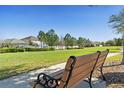 Scenic view of a community green space with a bench, perfect for relaxing and enjoying the peaceful surroundings at 6844 Butterfly Dr, Harmony, FL 34773