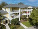 Three-story yellow condo complex showing multiple balconies and manicured landscaping at 709 Lucaya Loop # 1203, Davenport, FL 33897