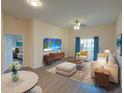 Cozy staged living room with hardwood floors, modern decor, leading to a bedroom at 709 Lucaya Loop # 1203, Davenport, FL 33897