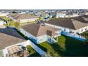 An aerial view of the home showing the fenced backyard, patio and neighborhood at 751 Jefferson St, Davenport, FL 33837