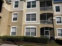 Multi-level condo building with patios and beige stucco exterior at 8103 Coconut Palm Way # 205, Kissimmee, FL 34747