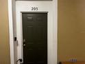 A solid, dark-green front door, unit 205, with secure lock and white trim at 8103 Coconut Palm Way # 205, Kissimmee, FL 34747